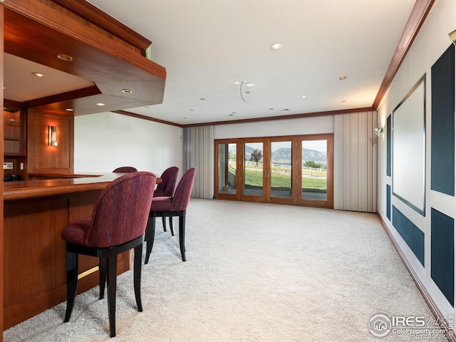 bar featuring crown molding, recessed lighting, light colored carpet, and a community bar