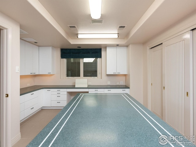 game room with light tile patterned floors, a tray ceiling, and visible vents