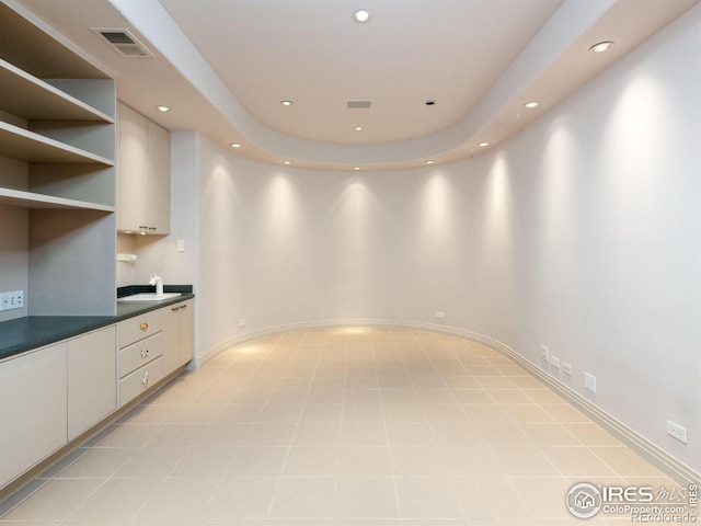 kitchen with a sink, dark countertops, recessed lighting, and visible vents