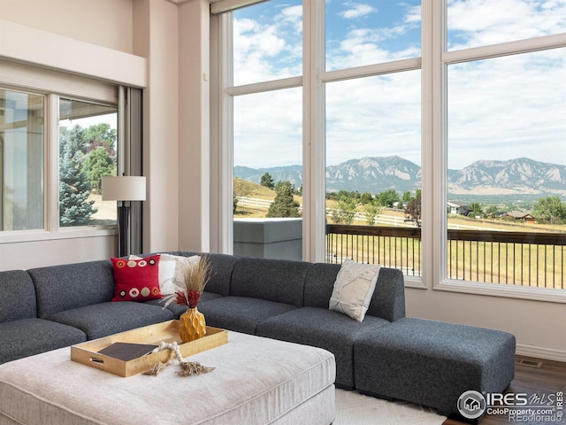 living room with visible vents, a mountain view, wood finished floors, and a wealth of natural light