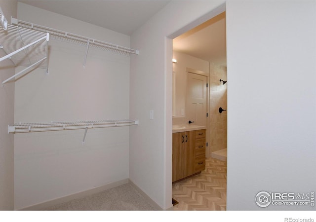 spacious closet with light parquet flooring