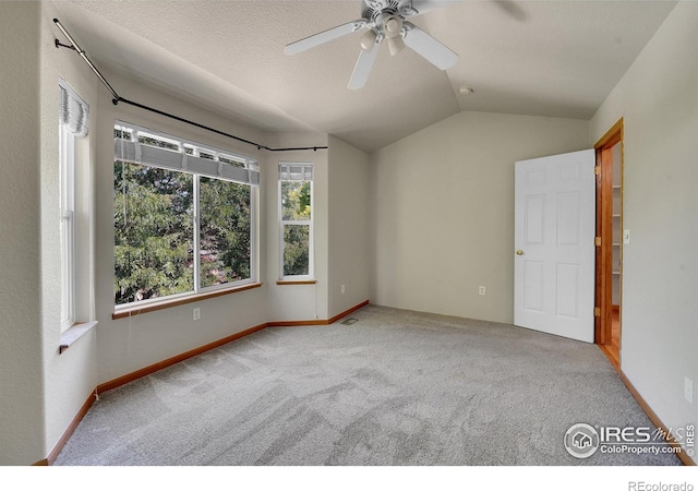 unfurnished room with a textured ceiling, lofted ceiling, light carpet, and ceiling fan