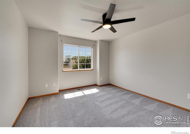 spare room with a textured ceiling, light carpet, and ceiling fan