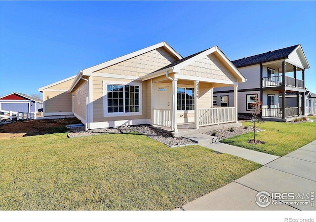 view of front of home with covered porch, a balcony, and a front lawn