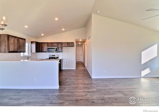 kitchen with high vaulted ceiling, stainless steel appliances, and hardwood / wood-style flooring