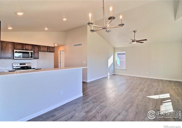 kitchen featuring ceiling fan with notable chandelier, stainless steel appliances, dark brown cabinetry, wood-type flooring, and high vaulted ceiling