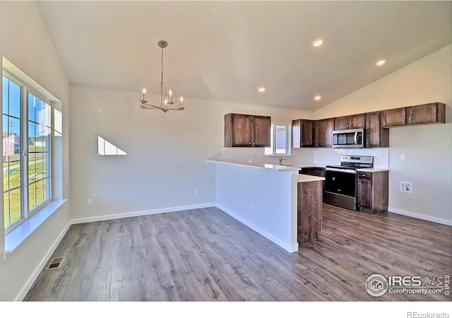 kitchen with kitchen peninsula, electric stove, pendant lighting, light hardwood / wood-style floors, and lofted ceiling