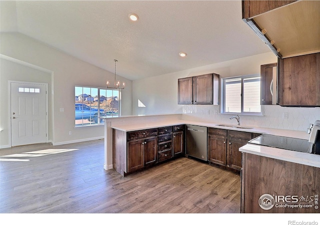 kitchen with stainless steel dishwasher, decorative light fixtures, plenty of natural light, and lofted ceiling