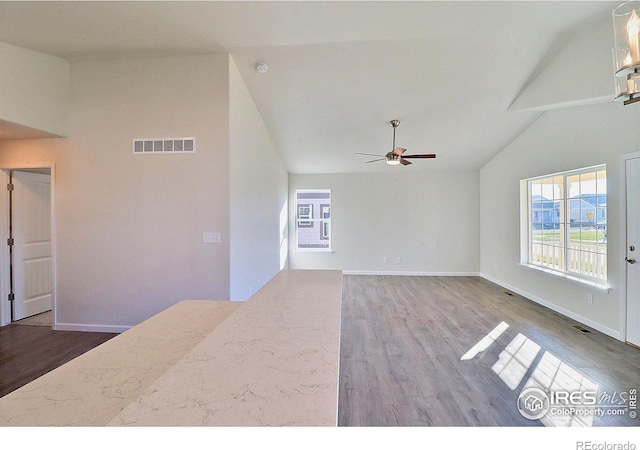 unfurnished living room with ceiling fan, hardwood / wood-style floors, and vaulted ceiling