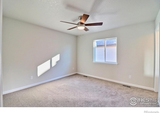 carpeted spare room with ceiling fan and a textured ceiling