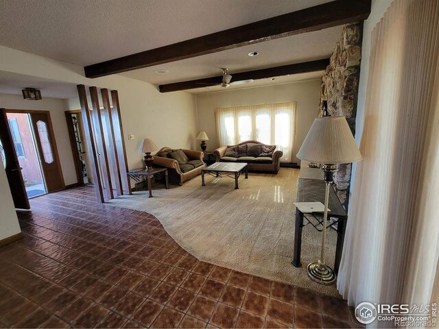 tiled living room with beam ceiling, ceiling fan, and a textured ceiling