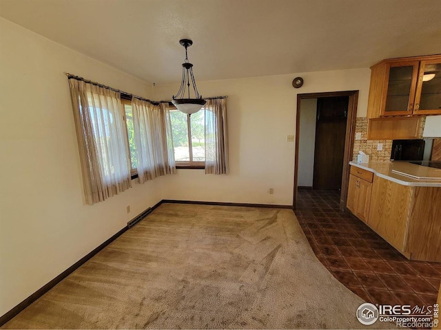 unfurnished dining area featuring dark tile patterned floors