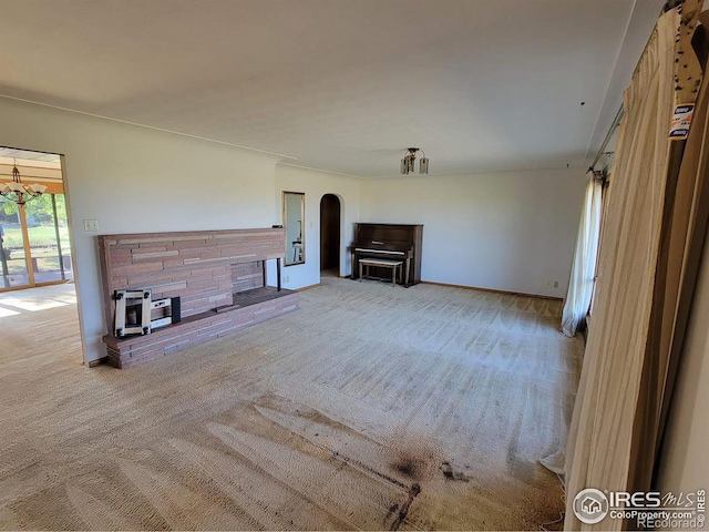 unfurnished living room featuring a notable chandelier and carpet