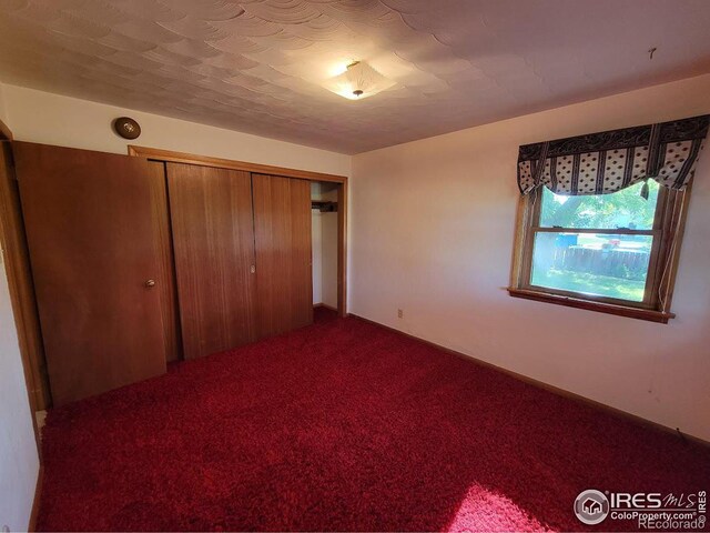 unfurnished bedroom featuring carpet flooring and a closet