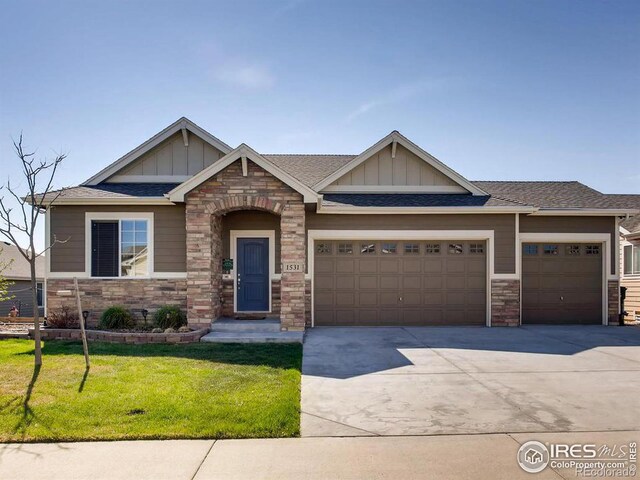 craftsman house with a front lawn and a garage