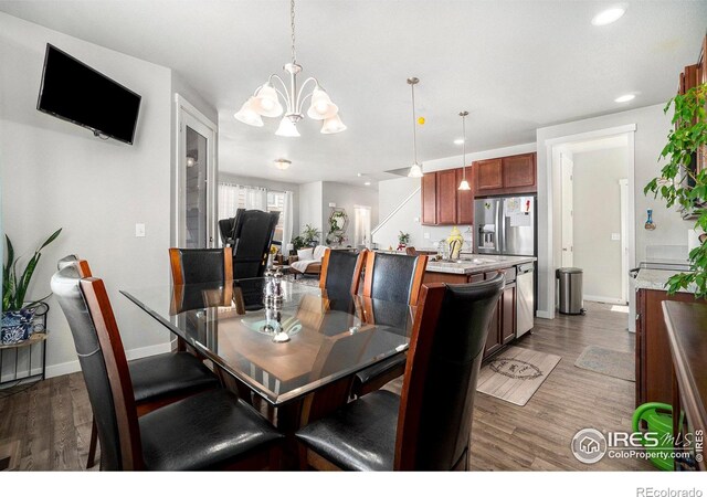 dining space with a notable chandelier and dark hardwood / wood-style flooring