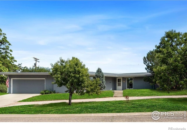 ranch-style home featuring an attached garage, concrete driveway, and a front yard