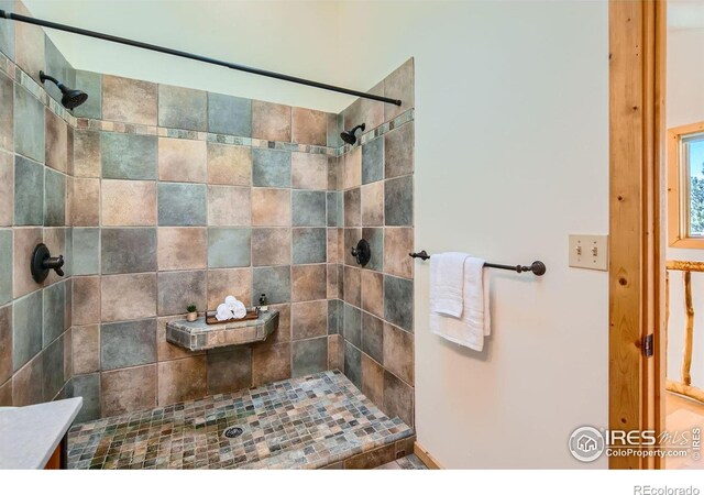 bathroom featuring a tile shower and vanity