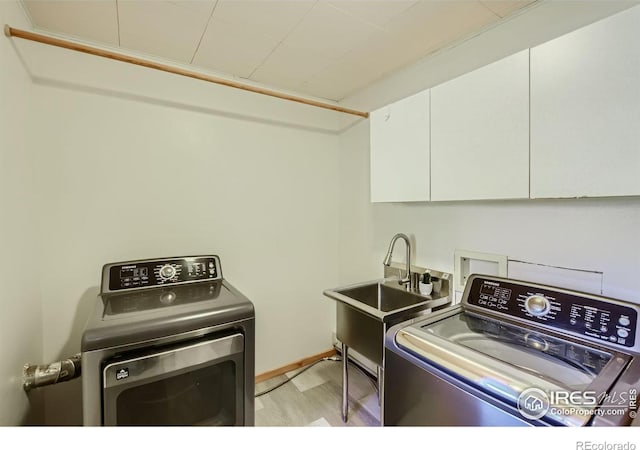 washroom featuring cabinets, light hardwood / wood-style floors, separate washer and dryer, and sink