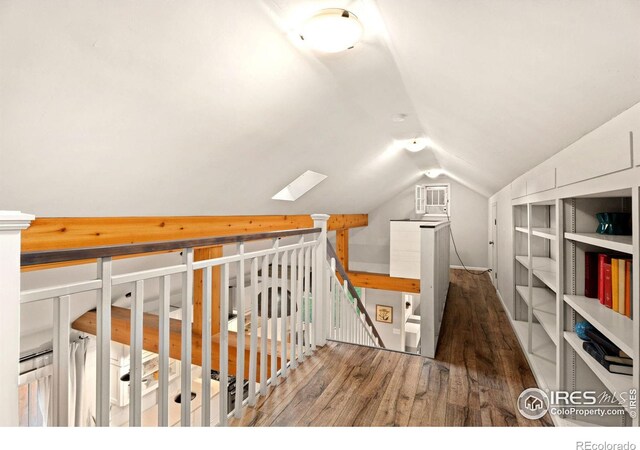 hallway featuring lofted ceiling with skylight and hardwood / wood-style flooring