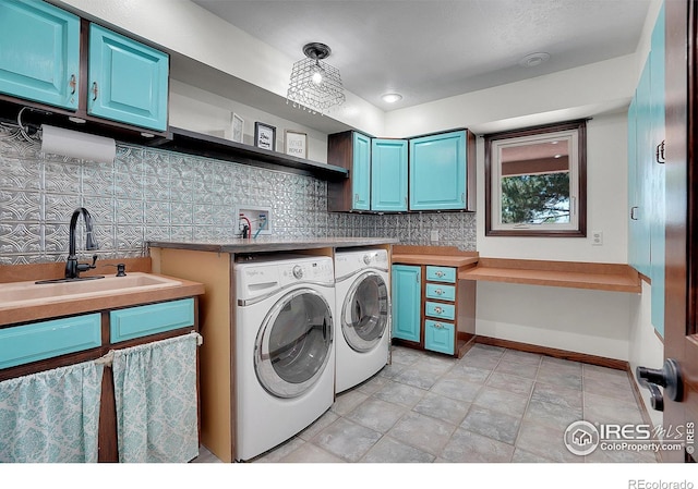 washroom with cabinets, sink, and washing machine and clothes dryer