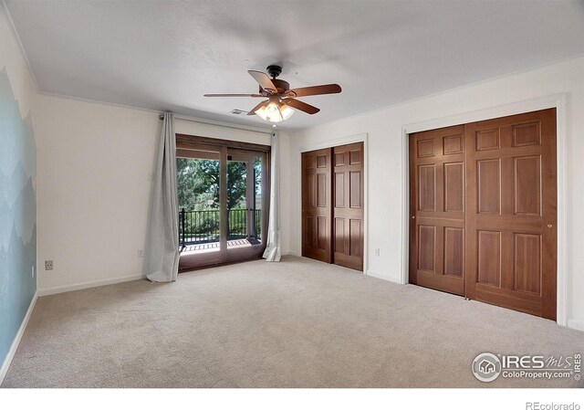 unfurnished bedroom featuring ceiling fan, multiple closets, light carpet, and access to exterior