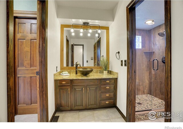 bathroom with tile patterned flooring, vanity, and a shower with shower door