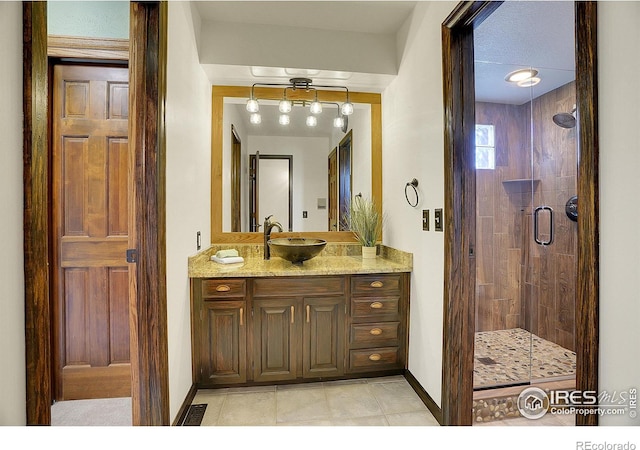 full bath featuring tile patterned flooring, vanity, visible vents, baseboards, and a shower stall