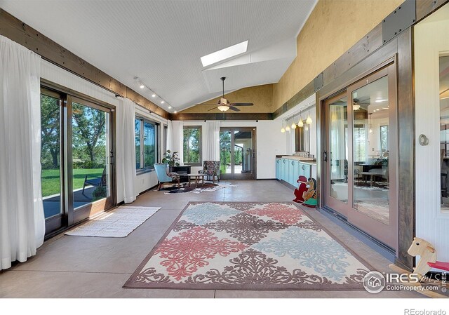 sunroom / solarium featuring a healthy amount of sunlight, lofted ceiling with skylight, and ceiling fan