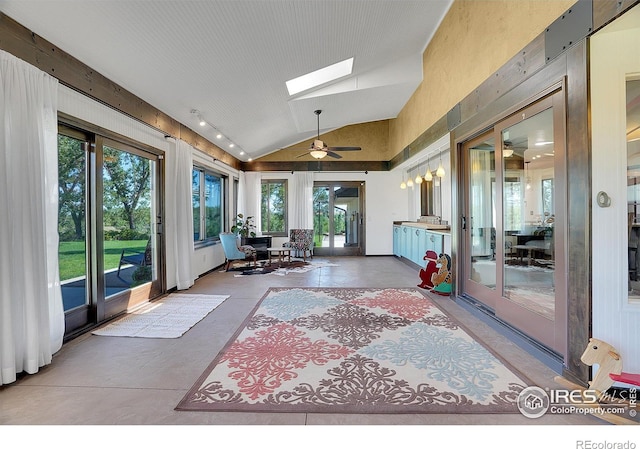 sunroom / solarium featuring a ceiling fan and vaulted ceiling with skylight