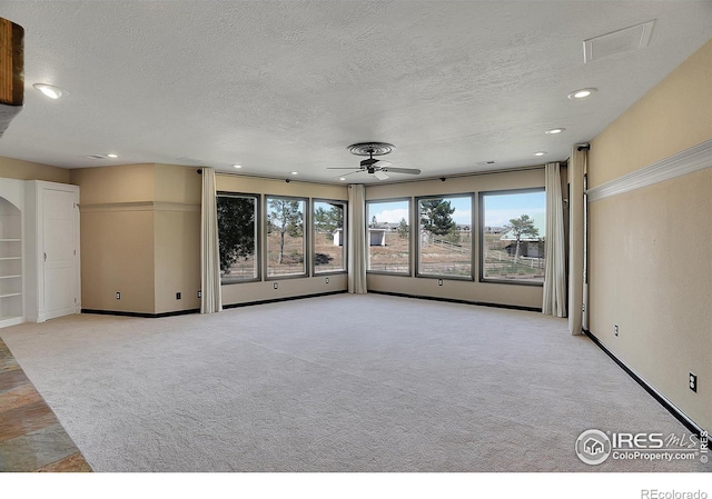 unfurnished room with recessed lighting, light carpet, ceiling fan, a textured ceiling, and baseboards