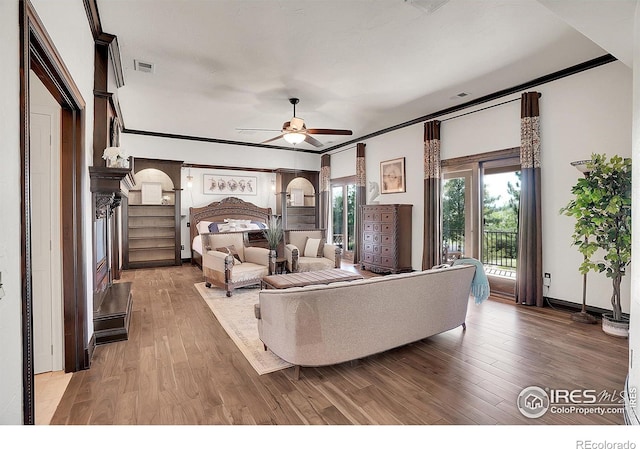 bedroom with arched walkways, access to outside, light wood finished floors, and visible vents