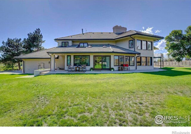 back of house featuring a patio, a yard, and a sunroom