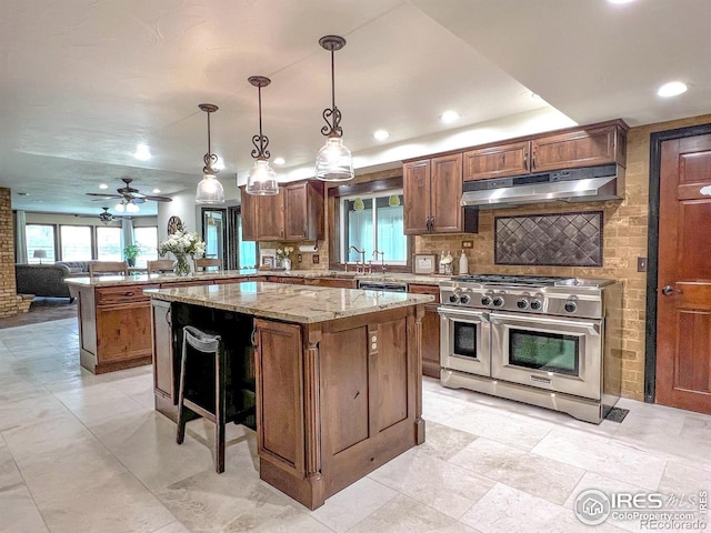 kitchen with ceiling fan, hanging light fixtures, kitchen peninsula, stainless steel appliances, and a center island