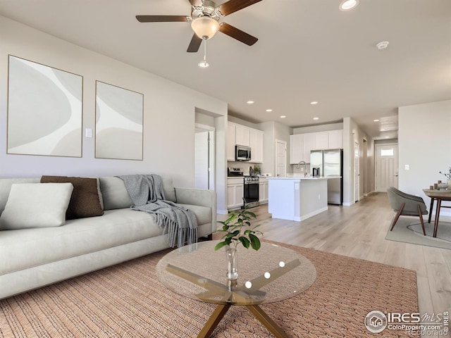 living area with a ceiling fan, light wood-type flooring, and recessed lighting