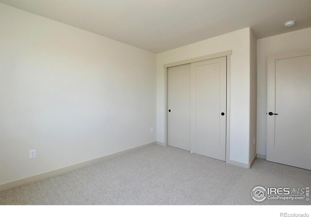 unfurnished bedroom featuring carpet and a closet