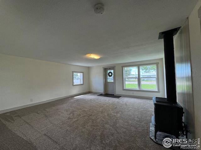 interior space with a textured ceiling and a wood stove