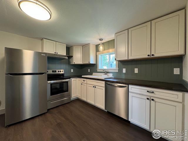 kitchen featuring white cabinets, appliances with stainless steel finishes, sink, and dark hardwood / wood-style flooring