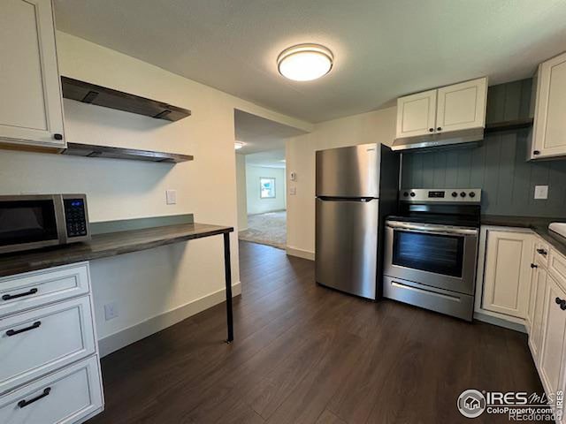 kitchen featuring range hood, white cabinets, appliances with stainless steel finishes, and dark hardwood / wood-style flooring