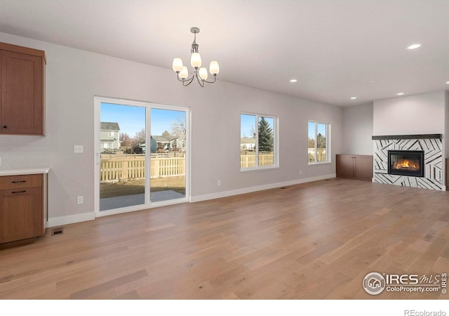 unfurnished living room with light hardwood / wood-style floors and an inviting chandelier