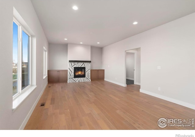 3288 Buffalo Grass Ln, Wellington, CO 80549 - unfurnished living room featuring light wood finished floors, recessed lighting, a fireplace, and baseboards