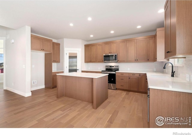 3288 Buffalo Grass Ln, Wellington, CO 80549 - kitchen featuring stainless steel appliances, a sink, a center island, tasteful backsplash, and light wood-type flooring