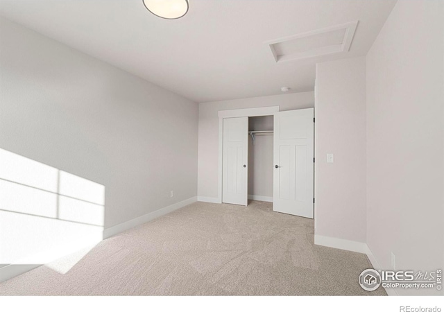 unfurnished bedroom featuring light carpet and a closet