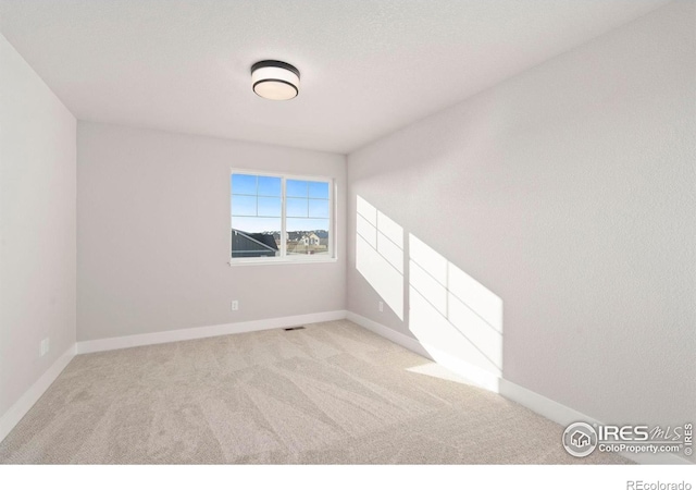 unfurnished room featuring light colored carpet