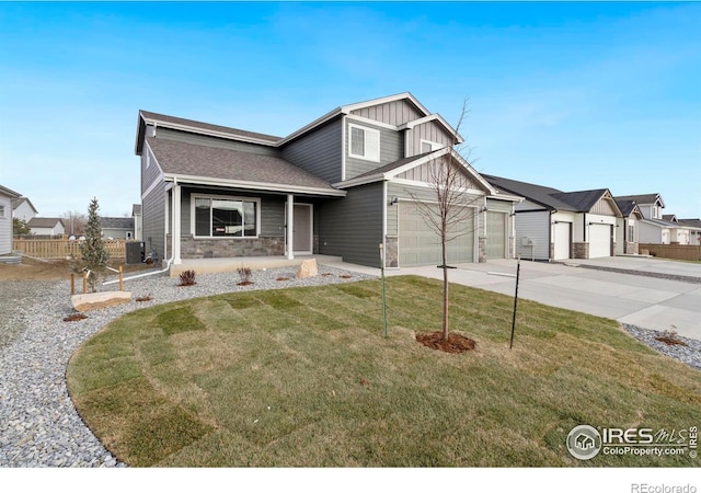 view of front of home with a garage, a front lawn, and central air condition unit