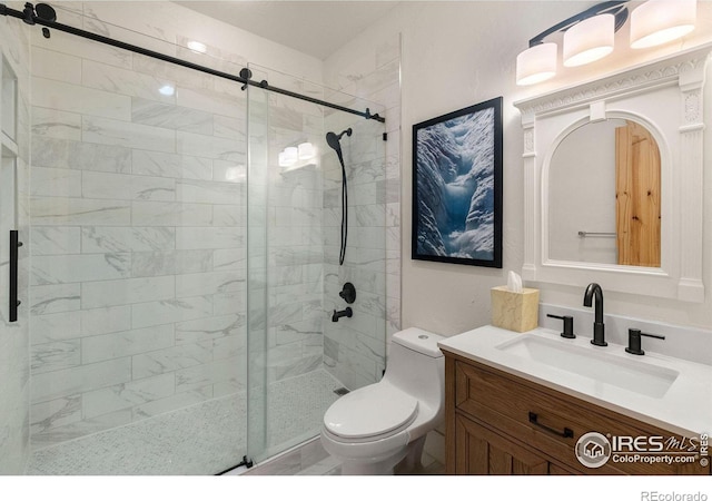 bathroom with a shower with shower door, vanity, and toilet