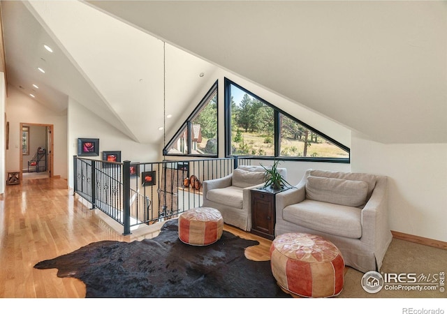 living area featuring high vaulted ceiling and light wood-type flooring