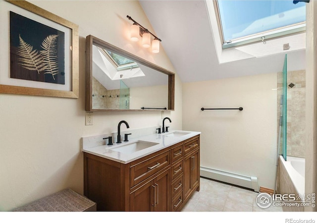 full bath with double vanity, lofted ceiling with skylight, a baseboard heating unit, and a sink