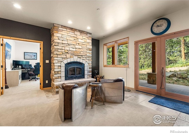 living room featuring a stone fireplace and light carpet