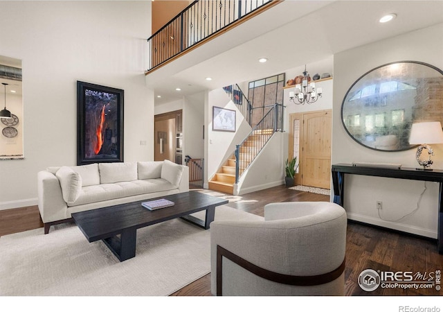 living room with dark hardwood / wood-style flooring and a towering ceiling